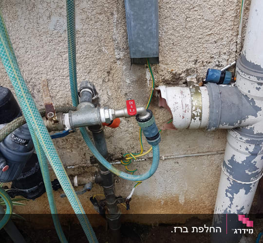 צינורות מים וברזים מחוברים לקיר חיצוני